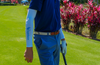 Person in blue golf attire on a golf course with pink foliage in the background
